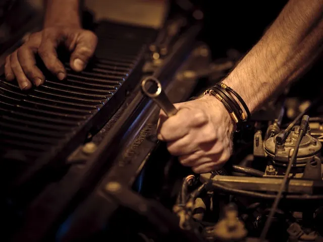 A man wrenching at a car.